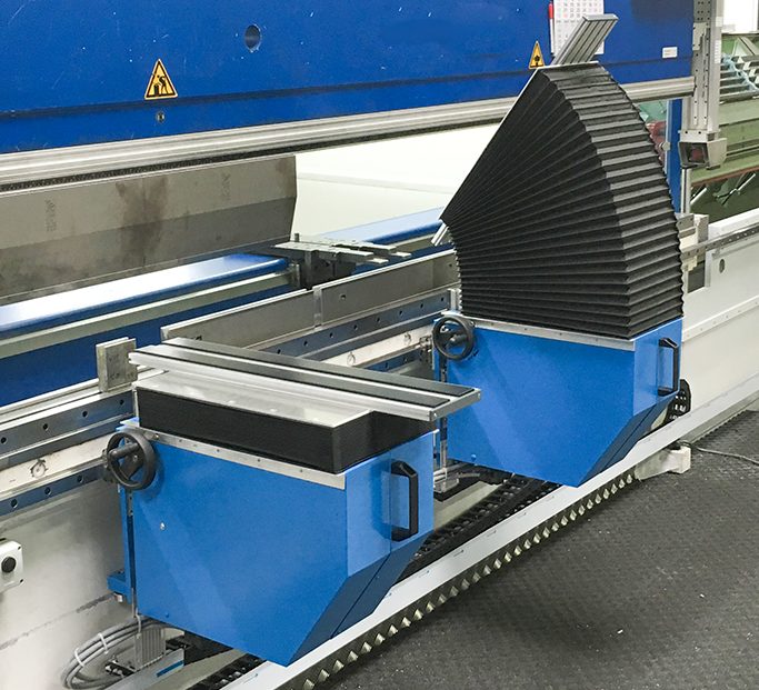 Bigehilfen vor einer Abkantpresse Maschine mit zwei blauen Biegehilfen und einem verstellbaren, schwarzen Schutzdeckel.