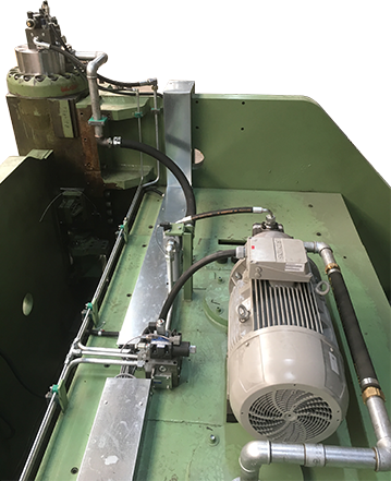 Verrohrung einer Hydraulik mit Hydraulikpumpe Maschine mit Motor und hydraulischen Komponenten auf einer grünen Oberfläche.